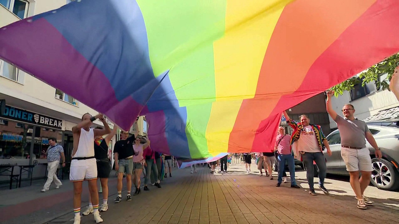 Menschen hissen eine LGBT-Flagge in Essen