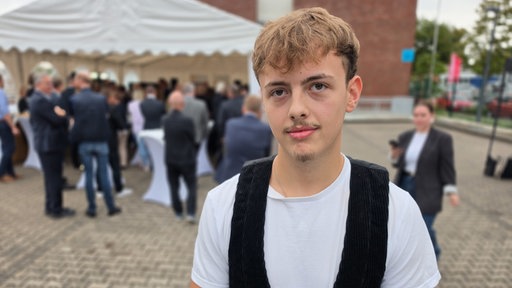 Ein junger Mann mit hellbraunen Haaren und braunen Augen trägt seine Zimmerer-Kluft.