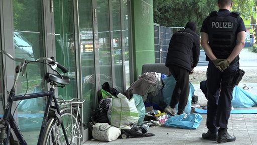 Ein Obdachloser wird von der Polizei begleitet den Platz vor dem Grünen Salon zu verlassen.