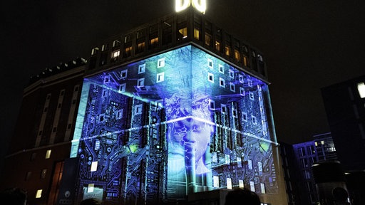 Erleuchtete Fassade des Dortmunder U-Gebäudes in blau mit futuristischen Motiven