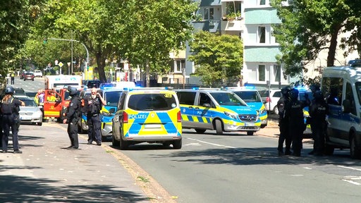 Polizeiwagen versperren eine Straße neben einem Wohnkomplex