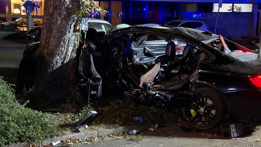 Kaputtes Auto frontal gegen Baum