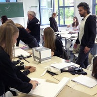 Schüler und Schülerinnen in einem Klassenzimmer schneiden und hantieren an Styroporplatten
