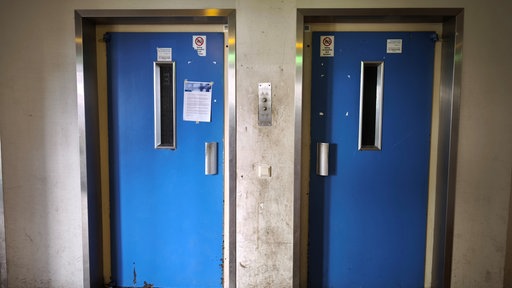 Zwei blaue Türen zweier Fahrstühle.