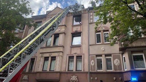 Ausgefahrene Drehleiter der Feuerwehr lehnt an einem Mehrfamilienhaus in Dortmund.