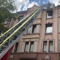 Ausgefahrene Drehleiter der Feuerwehr lehnt an einem Mehrfamilienhaus in Dortmund.