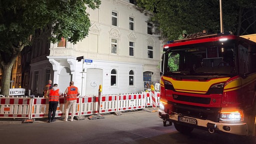 Ein Feuerwehr-Fahrzeug steht vor einem Wohnhaus in Dortmund welches einsturzgefährdet ist.