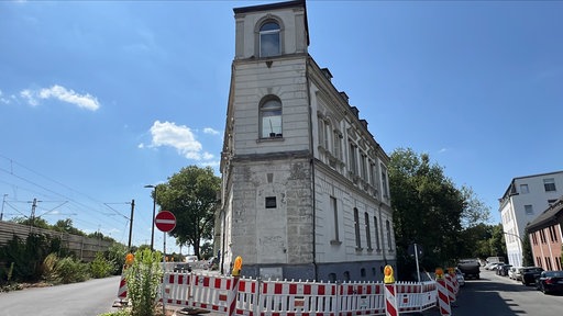Ein sichtilich in die Jahre gekommenes Haus, um das Absperrungen gebaut worden sind
