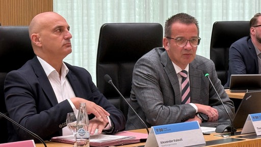 Alexander Kalouti und Thorsten Bunte sitzen auf schwarzen Bürostühlen.