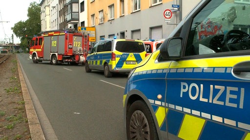Polizei und Feuerwehr stehen auf der Straße vor dem Haus