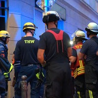 Einsatzkräfte des THW und der Feuerwehr Dortmund stehen vor einem Gebäude.