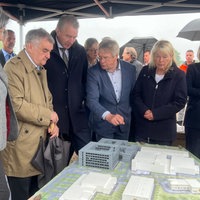 Innenminister Herbert Reul, Polizeipräsidentin Friederike Zurhausen, die Investoren und weitere Beteiligte begutachten das Miniatur-Modell der neuen Polizeigebäude  