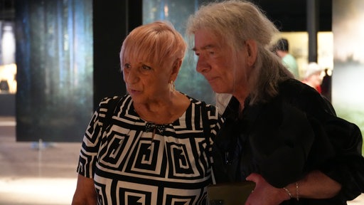 Zwei Besucher schauen auf ein Foto in der Ausstellung "Mythos Wald"