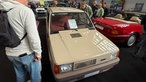 Ein beiger, älterer Fiat Panda auf einer Messe.