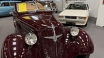 Ein weinroter Oldtimer des Herstellers Adler in einer Messehalle.