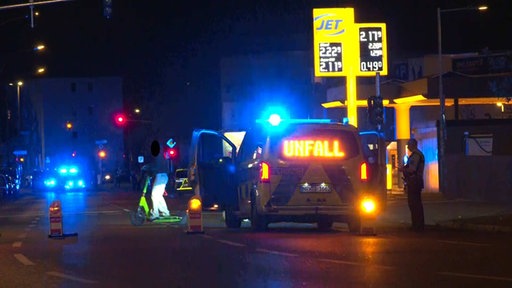 Polizeiwagen mit einem Unfall-Hinweis vor einer Tankstelle