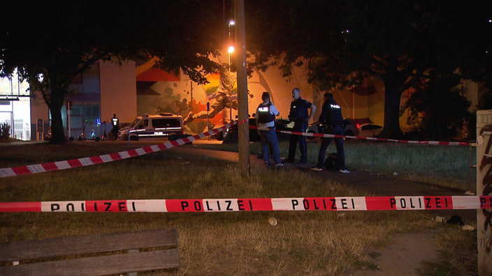 Ein abgesperrter Bereich bei Nacht. Drei Polizisten stehen im Hintergrund
