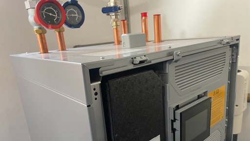 Eine Wärmepumpe im Keller mit Armaturen.