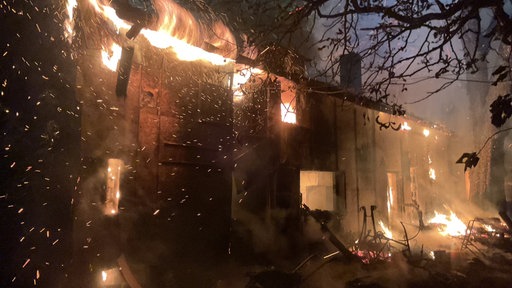 Ein Haus steht in Flammen, es brennt lichterloh. 