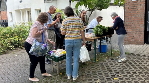 Mehrere Personen suchen sich gerettete Lebensmittel aus