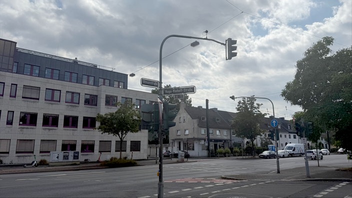 Straßenkreuzung Ulmenstraße / Hugo-Viehoff-Straße in Düsseldorf mit Ampelanlage vor Häusern unter einem bewölkten Himmel.