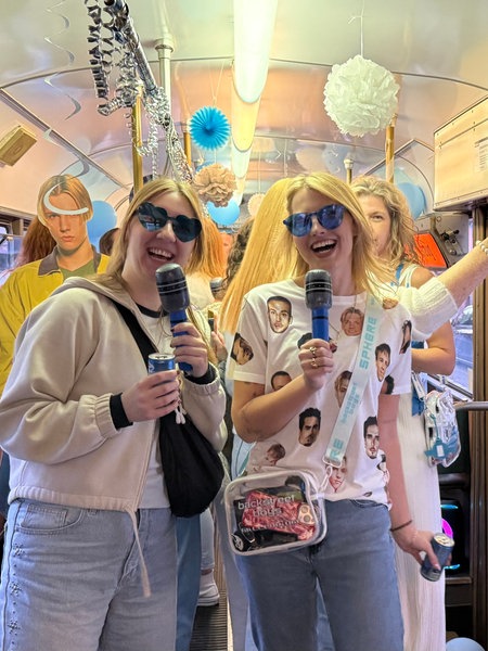 Zwei weibliche Fans fahren verkleidet und mit blauen Sonnenbrillen in der Backstreet Boys - Express-Straßenbahn durch Düsseldorf.