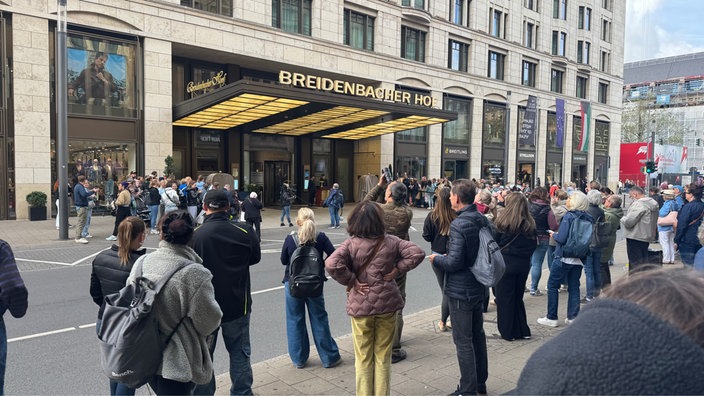 Außenfassade des Breidenbacher Hofs an der Königsallee in Düsseldorf. Viele Menschen sind vor dem Gebäude versammelt.