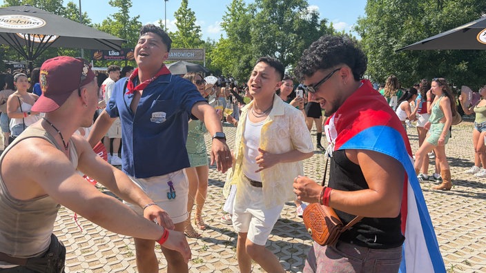 Vier Männer tanzen ausgelassen.