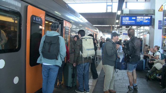 Menschen in Düsseldorf steigen in den Zug