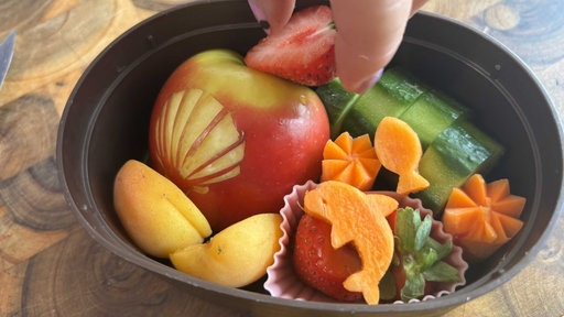 Eine mit verzierten Früchten gefüllten Bentobox