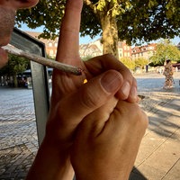 Ein Mann zündet sich einen Joint in Düsseldorf an