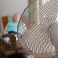 Seniorin sitzt vor einem Ventilator