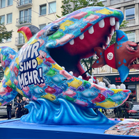 Ein Mottowagen auf der Demo, dargestellt ist ein großer Fisch der einen kleineren frisst, der größere beschriftet mit "Wir sind mehr", der keiner mit "Wir sind das Volk"