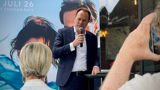 Ein Mann im Anzug hält eine Rede.