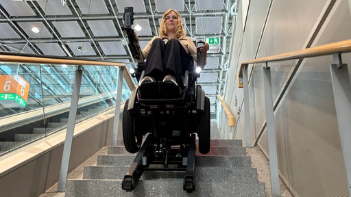 Svenja Gluth sitzt in einem Rollstuhl und bewegt sich damit eine Treppe hinunter