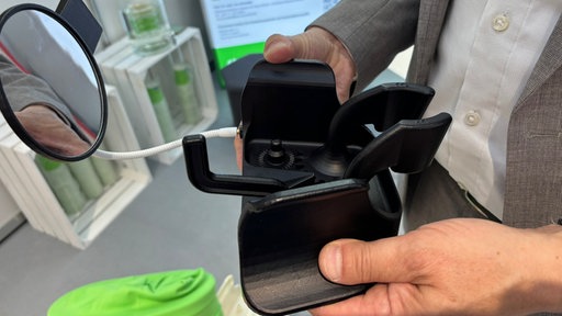 Tulip ist eine schwarze  Plastikgerätschaft, die querschnittgelähmten Frauen beim Toilettengang helfen kann