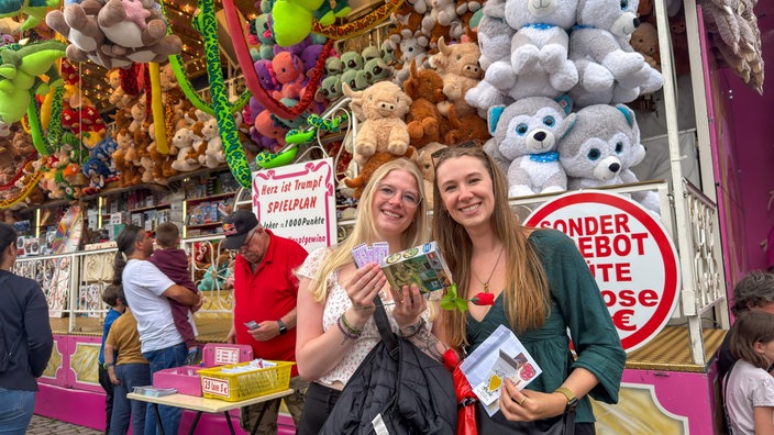 Zwei Freundinnen vor einer Losbude auf der Düsseldorfer Rheinkirmes