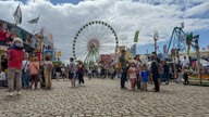 Imbissbuden und Fahrgeschäfte auf der Düsseldorfer Rheinkirmes mit Blick aufs Riesenrad