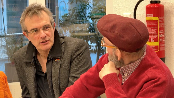 Zwei Männer sind in ein Gespräch vertieft