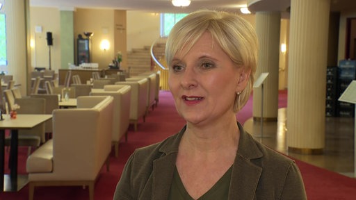 Eine Frau mit kurzen, blonden Haaren steht in der Düsseldorfer Oper.
