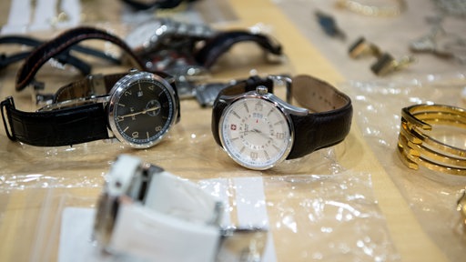 Symbolbild: Erbeuteter Schmuck liegt nach einem Einbruch bei der Polizei. Unter anderem sind Uhren zu sehen.