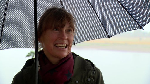 Eine Frau mit Regenschirm im Regen