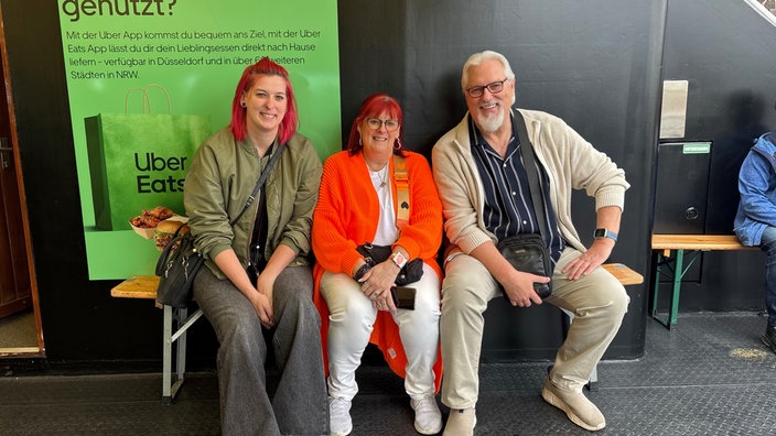 Jessica Prang, Susan Prang und Jürgen Prang sitzen auf einer Bank auf der Kirmesfähre