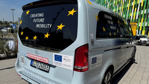 Ein Shuttlebus mit einem Schild "Testfahrt" vor dem EUREF - Campus in Düsseldorf