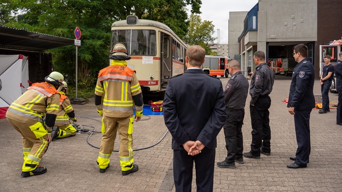 Die Düsseldorfer Feuerwehr demonstriert, wie sie eine Bahn anheben kann, um darunter gefangene Menschen zu retten.