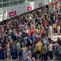 An den Gepäckschaltern am Flughafen Düsseldorf stehen viele Menschen an.