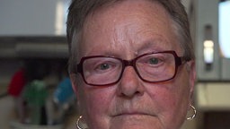 Eine Frau im Portrait. Sie sieht traurig aus.