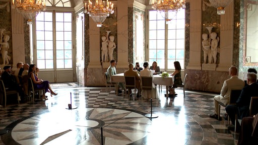 Ein Blick ins Schloss Benrath: An einem Tisch sitzt ein Brautpaar und wird gerade verheiratet.