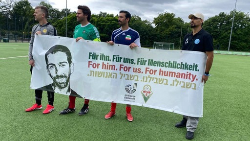 Mehrere Spieler halten ein Banner für Ilan Fiorentino in den Händen