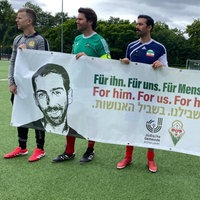 Mehrere Spieler halten ein Banner für Ilan Fiorentino in den Händen